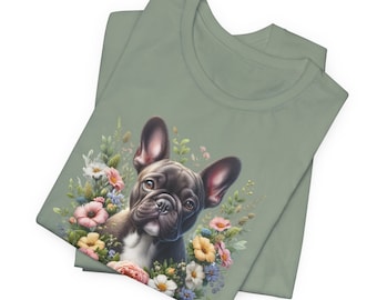 May include: A sage green t-shirt featuring a black and white French bulldog surrounded by colourful flowers. The dog is looking at the viewer.