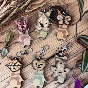 Peut inclure: Six porte-clés en bois représentant différents personnages du jeu vidéo "The Legend of Zelda: Breath of the Wild". Chaque porte-clés est d'une couleur différente et présente un design unique. Les porte-clés sont tous en bois et ont un anneau métallique pour les attacher aux clés.