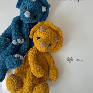 Könnte beinhalten: Zwei gehäkelte Triceratops-Spielzeuge, eines blau und eines gelb, mit dem Text "Crochet pattern "Triceratops" Author Nika Rasumovski" auf weißem Hintergrund.