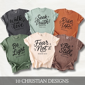 Może przedstawiać: Kolekcja dziesięciu koszulek w różnych kolorach, każda z innym motywem chrześcijańskim w czarnym skrypcie. Koszulki wyświetlają frazy takie jak „Walk in Love”, „Seek Truth” i „Rise Up” z odpowiednimi wersetami biblijnymi. Tekst „10 CHRISTIAN DESIGNS” znajduje się na dole.