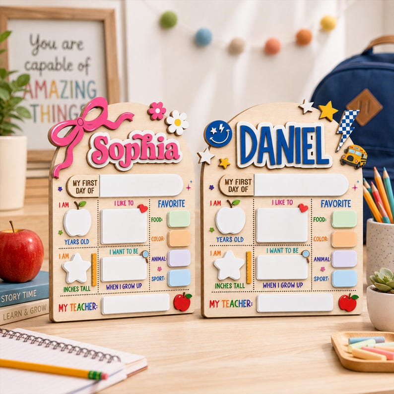 May include: Two arched wooden signs for the first day of school, personalized with the names Sophia and Daniel. Each sign features white dry-erase sections for details like age, height, teacher, and favorites, decorated with colorful icons.