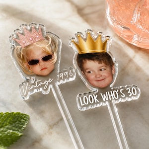 Puede incluir: Dos adornos para tarta de acr&iacute;lico transparente con fotos impresas de ni&ntilde;os con coronas. El adorno izquierdo muestra a un ni&ntilde;o con una corona de oro rosa y el texto Vintage 1996. El derecho muestra a un ni&ntilde;o con una corona dorada y el texto LOOK WHO'S 30.