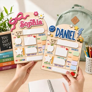May include: Two wooden first day of school signs featuring the names Sophia and Daniel in raised lettering. Each board includes sections for age, height, teacher, and favorites like food, color, animal, and sport, with blank white spaces for writing.