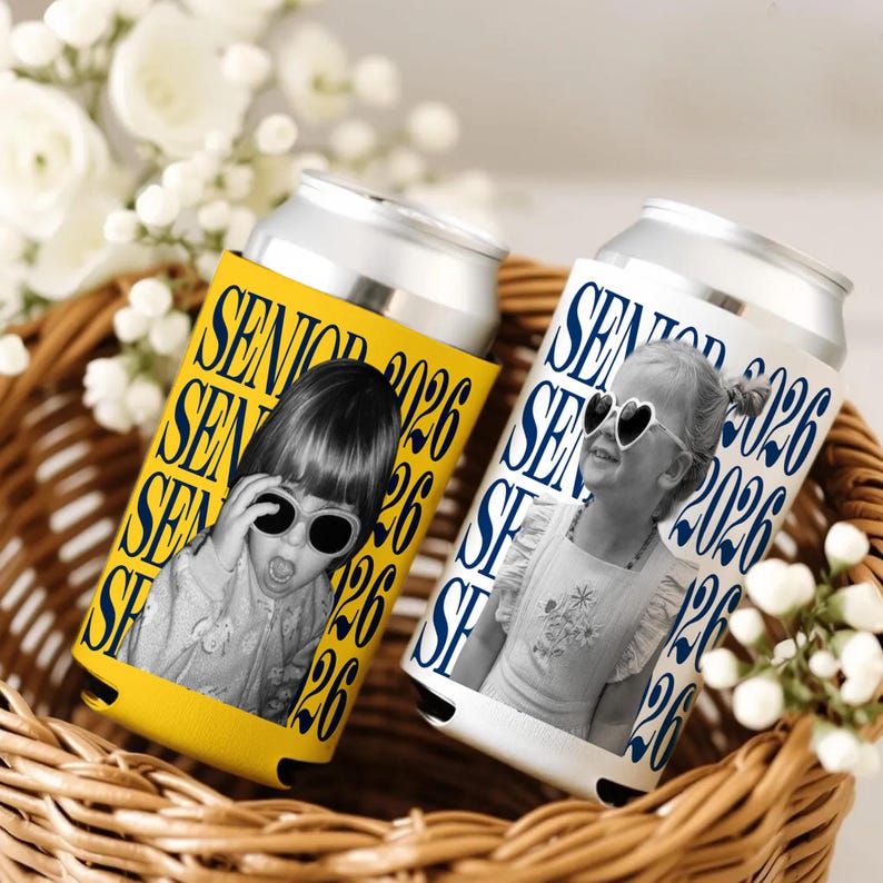 Puede incluir: Dos enfriadores de latas de aluminio con fotos de ni&ntilde;os con gafas de sol. Uno es amarillo con el texto "SENIOR 2026" en azul, el otro es blanco con el mismo texto en azul. Est&aacute;n en una cesta de mimbre.