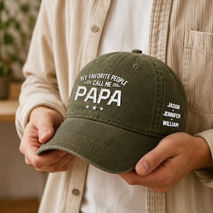 May include: Olive green baseball cap with the text "MY FAVORITE PEOPLE CALL ME PAPA" in white. The cap also features three stars and the names Jason, Jennifer, and William.