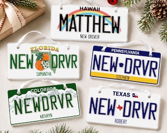 May include: Five rectangular white ornaments shaped like license plates with white ribbon hangers. They feature state names, custom names like Matthew, Samantha, Stephen, Kathryn, and Robert, and text including New Driver or New Drvr.