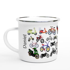 以下が含まれることがあります： カラフルな自転車、スクーター、オートバイが描かれた白いエナメルマグ。マグの側面には「Daniel」という名前が縦に印刷されています。マグには銀色の縁と白いハンドルが付いています。