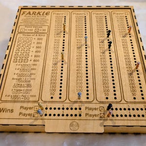May include: Wooden Farkle game board with scoring columns for multiple players. The board has engraved text and point values, with pegs marking scores. A fun family game.