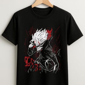 May include: Black t-shirt featuring a graphic of a character with white hair, red accents, and a skeletal grin. The design includes red lightning bolt-like shapes and Japanese text. The shirt is hanging on a wooden hanger.