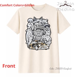 May include: Ivory-colored t-shirt with a graphic design featuring the text "LA RAZA Aztlan" and various cultural figures and a classic car. The shirt also has the text "Comfort Colors+Gildan" and "Front" printed on it. The color is Ivory (Comfort).