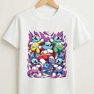 May include: White t-shirt featuring a graphic of cartoon turtles in various colors, including yellow, green, red, purple, and blue. The turtles are set against a purple background. The shirt is hanging on a wooden hanger.