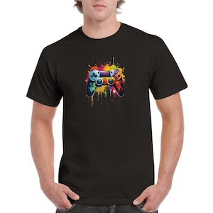 Peut inclure: Un t-shirt noir avec un motif de manette de jeu vidéo éclaboussé de peinture colorée.