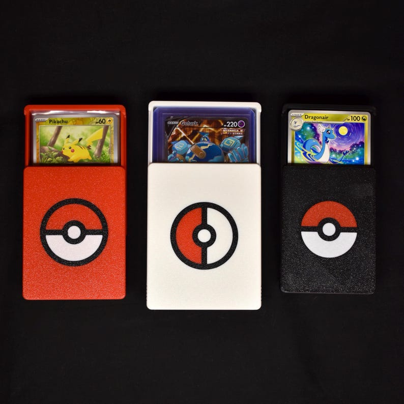 Pu&ograve; includere: Tre custodie rettangolari per carte collezionabili in rosso, bianco e nero. Ogni custodia presenta un emblema circolare Pok&eacute; Ball sulla parte anteriore e contiene una carta, raffigurante Pikachu, Golurk e Dragonair.