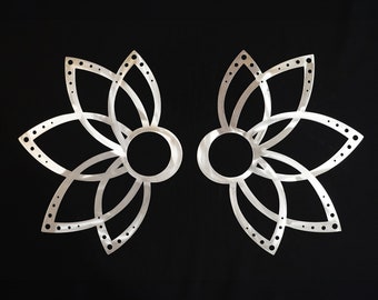 May include: A pair of silver-toned ear cuffs featuring a symmetrical, open-work lotus flower design. Each piece consists of a central circular opening surrounded by multiple petal-shaped loops, with small circular perforations along the outer edges.