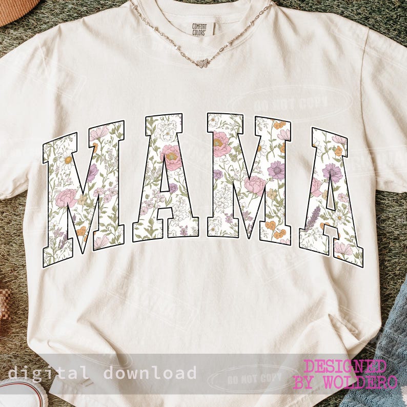 May include: Cream-colored t-shirt with the word "MAMA" in large, floral-patterned letters. The flowers are in shades of pink, purple, and yellow. The shirt has a crew neck and short sleeves. The text "digital download" is at the bottom.