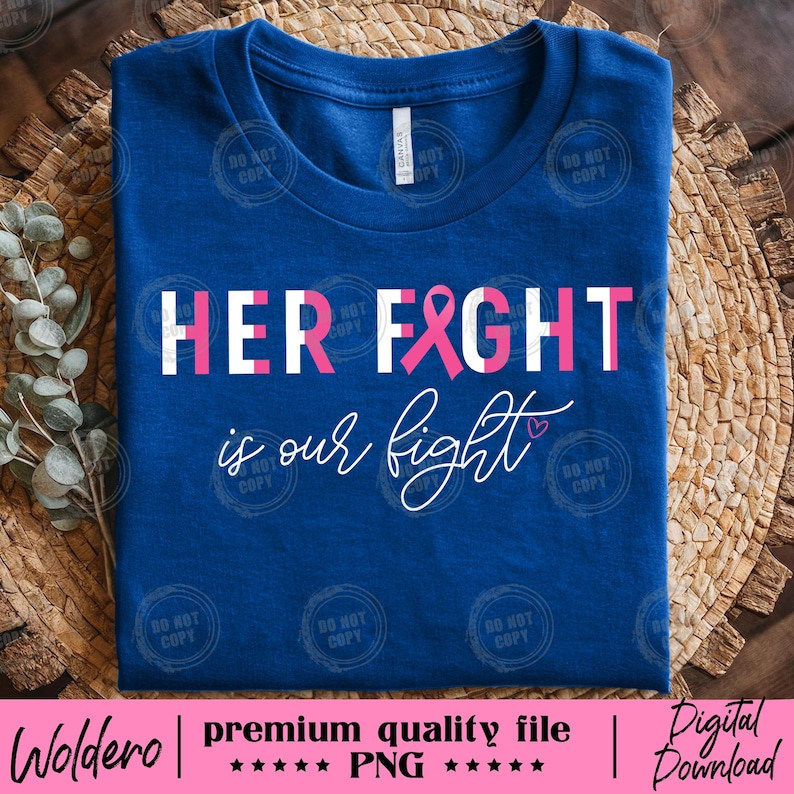 May include: A blue t-shirt with the text "HER FIGHT" in white and pink, with a pink ribbon graphic. Below, the text "is our fight" is written in cursive. The shirt is on a woven background.