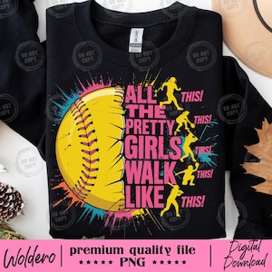 Könnte beinhalten: Schwarzes Sweatshirt mit Softball-Grafik. Das Design zeigt einen gelben Softball mit rosa Nähten und den Text "ALL THE PRETTY GIRLS WALK LIKE THIS!" in Rosa und Weiß. Gelbe Silhouetten von Softballspielerinnen sind ebenfalls enthalten.
