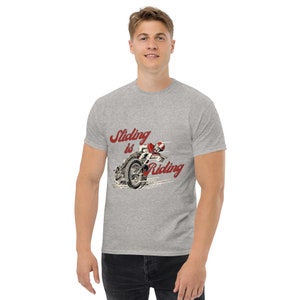 May include: A gray t-shirt with a red graphic of a motorcycle rider with the text "Sliding is Riding".