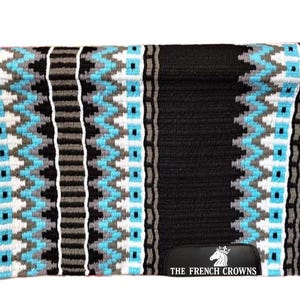 May include: A black horse saddle pad with a geometric pattern in shades of blue, gray, and white. The pad has a rectangular shape and a black bottom with the text "THE FRENCH CROWNS".