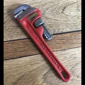 May include: A red pipe wrench with a silver handle and the text "RIDGID 14" printed on the handle.