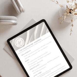 May include: A grey tablet with a white and grey abstract design on the screen. The tablet displays a client consultation form for microblading. The form includes sections for basic information, address, emergency contact, and medical history.