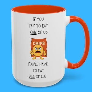 May include: White ceramic mug with an orange rim and handle. The mug features a cartoon chip bag with a face and the text "IF YOU TRY TO EAT ONE OF US CHIPS YOU'LL HAVE TO EAT ALL OF US!"