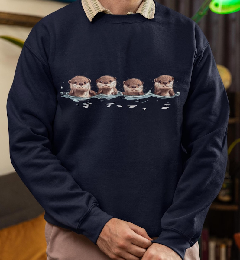 This unisex heavy blend crewneck sweatshirt shows cute otter offspring floating in a row. The adorable otter puppies are looking right at you, creating a whimsical and playful vibe. Perfect for animal lovers and those who enjoy cute, quirky designs.