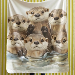 Può includere: Una coperta in pile bianco con un'illustrazione colorata di sei lontre che nuotano in un specchio d'acqua. Le lontre sono marroni e hanno occhi e nasi neri. L'acqua è di colore blu chiaro con schiuma bianca.