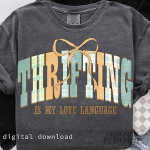 以下が含まれることがあります： チェック柄の「THRIFTING」の文字とリボンが描かれた濃いグレーのスウェットシャツ。「IS MY LOVE LANGUAGE」の文字が「THRIFTING」の下にあります。「digital download」と「designed by Rippent」の文字も表示されています。