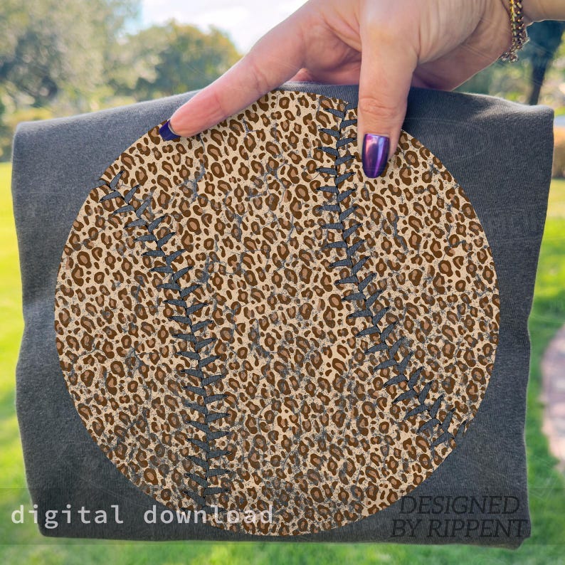 May include: A dark gray t-shirt featuring a baseball design with a leopard print pattern. The baseball has gray stitching details. The words "digital download" and "DESIGNED BY RIPPENT" are printed on the shirt.