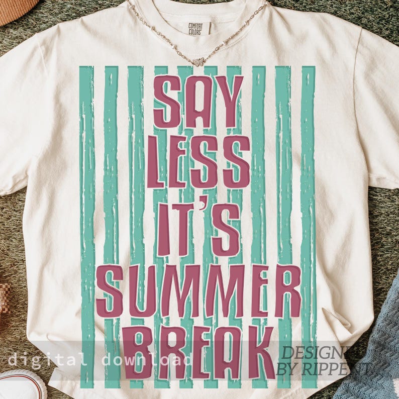 May include: Cream-colored t-shirt with the text "SAY LESS IT'S SUMMER BREAK" in a pink font, set against a backdrop of vertical teal stripes. The shirt has a relaxed fit and a crew neck.