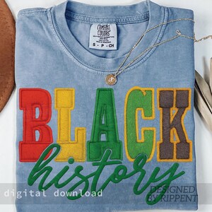 May include: A light blue t-shirt with the words "BLACK HISTORY" embroidered in red, yellow, green, and brown. The shirt has a crew neck and short sleeves. A gold necklace with a pendant rests on the shirt. The words "digital download" and "designed by Rippent" are also visible.