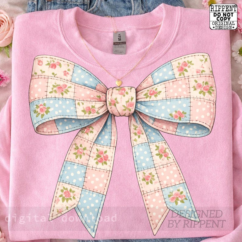 May include: A light pink sweatshirt featuring a large bow design. The bow is a patchwork of pink and blue squares with floral patterns and polka dots. A gold heart pendant necklace hangs from the neckline. The text "RIPPENT DO NOT COPY ORIGINAL DESIGN" is visible.
