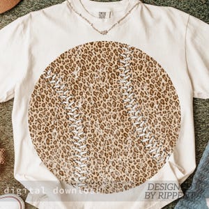 May include: Cream-colored t-shirt featuring a large baseball design with a leopard print pattern. The baseball has white stitching details. The text "digital download" is at the bottom left, and "DESIGN BY RIPPE" is at the bottom right.
