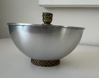 Puede incluir: Un tazón de plata con una tapa y una base de latón. La tapa tiene un adorno de piña.