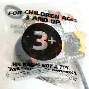 Puede incluir: Una bolsa de plástico transparente con una imagen en blanco y negro de un personaje de Star Wars. La bolsa tiene el texto "Para niños de 3 años en adelante." y "Esta bolsa no es un juguete. Deseche correctamente."