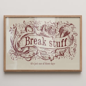 Puede incluir: Impresión enmarcada con la frase "Break stuff" en una pancarta decorativa burdeos, rodeada de adornos y elementos florales sobre un fondo crema. La frase "-it's just one of those days-" está debajo de la pancarta.