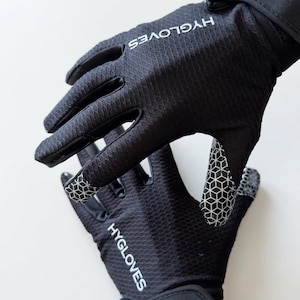 Puede incluir: Guantes negros con el texto blanco "HYGLOVES". Los guantes tienen una superficie texturizada y un patr&oacute;n geom&eacute;trico en las yemas de los dedos y la palma. Tienen una correa de mu&ntilde;eca para un ajuste seguro.