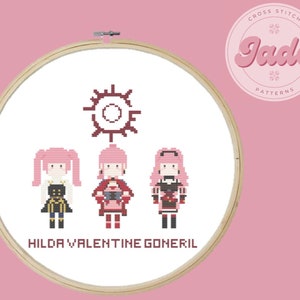 May include: Cross stitch pattern featuring three female characters with pink hair and different outfits, a sun symbol, and the text "HILDA VALENTINE GONERIL". The pattern is in a white embroidery hoop.