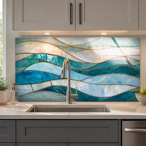 May include: A kitchen backsplash featuring a stained glass design with flowing, wave-like patterns in shades of deep blue, turquoise, and white, separated by thin metallic lines, positioned behind a stainless steel faucet and sink.