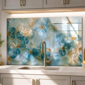 May include: A rectangular kitchen backsplash panel featuring a translucent, layered floral design in shades of teal, light blue, and cream. The artwork displays overlapping petals with delicate gold-toned outlines, creating a soft, ethereal appearance.