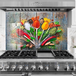 May include: A kitchen splashback showcasing a colourful arrangement of spices and herbs on antique spoons. The design includes red chillies, star anise, and various spices against a rustic wooden background. The image is installed above a stainless steel gas hob.