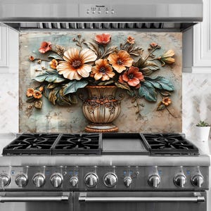 May include: A kitchen splashback with a detailed floral arrangement in a decorative vase. The flowers are in shades of orange, peach, and white, with green leaves. The splashback is above a stainless steel gas range.