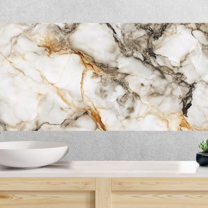 May include: A large rectangular marble-patterned wall panel with white, brown, and gray veining. A white oval sink and chrome faucet are in front of the panel. A small succulent in a black pot and folded towels are on the counter.