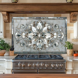 May include: A kitchen backsplash with a floral design made of mother-of-pearl and glass. The backsplash is framed in a silver metal. The kitchen also features a stainless steel stove, cream-coloured cabinets, and a wooden beam.
