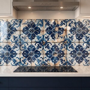 May include: A kitchen backsplash featuring square ceramic tiles with a repeating dark blue floral pattern on a white background. The tiles exhibit a distressed, weathered finish with brown accents, installed above a dark blue cabinet base.