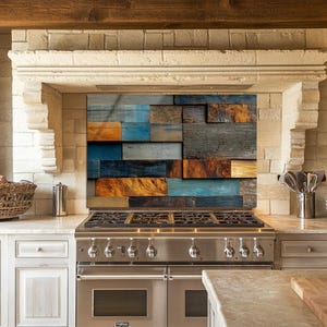 Puede incluir: Una cocina de gas de acero inoxidable con seis quemadores está empotrada en una encimera blanca. El protector contra salpicaduras presenta un mosaico de tablones de madera en tonos azules, naranjas y grises. Un arco de piedra enmarca la zona de cocción.