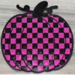 May include: A pumpkin-shaped decorative item featuring a vibrant hot pink and black checkered pattern. The object has a black outline and a black stem at the top, with a flat, rounded silhouette that mimics the appearance of a classic pumpkin.