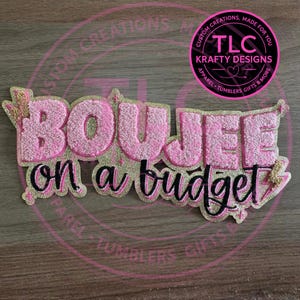 May include: Pink and gold glitter "Boujee on a budget" design. The text is in a bubble font with a glitter outline. The design includes a lightning bolt and a logo that says "TLC Krafty Designs".