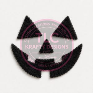 May include: A set of five black fuzzy fabric cutouts arranged to form a jack-o'-lantern face, consisting of two triangular eyes, a triangular nose, and a wide curved mouth. A circular watermark with the text TLC KRAFTY DESIGNS is overlaid.